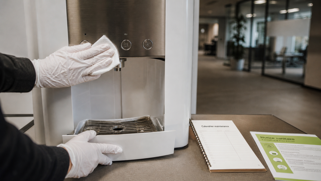 Entretien fontaine à eau : mains gantées, lingette désinfectante et calendrier maintenance